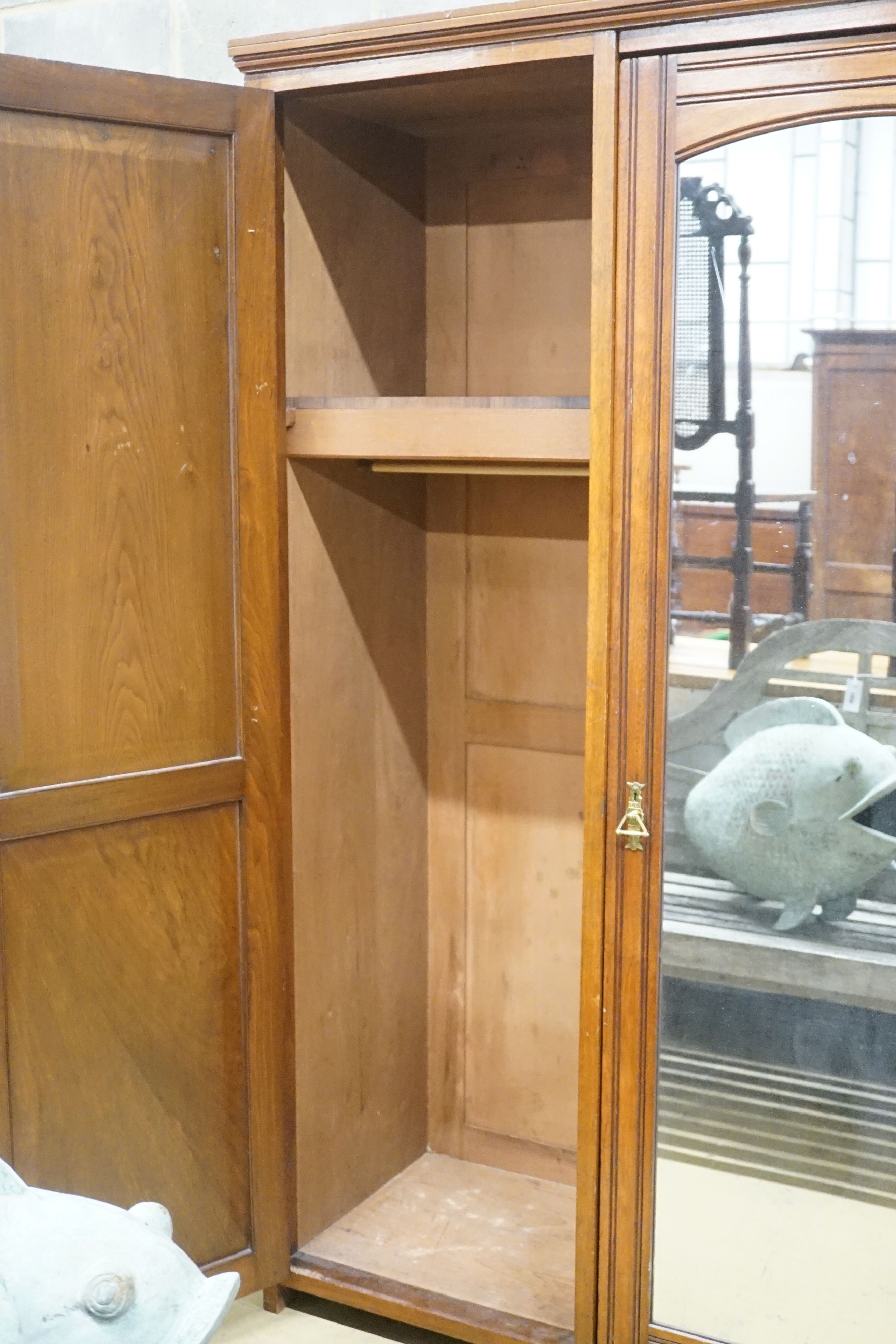 A late Victorian aesthetic movement walnut triple wardrobe, width 187cm depth 56cm height 203cm